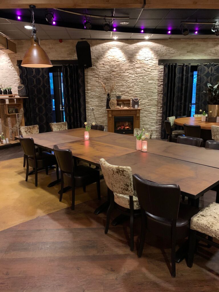 Zaal met samengevoegde tafels en openhaard